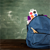 Blauer Schulrucksack mit Schulsachen gefüllt